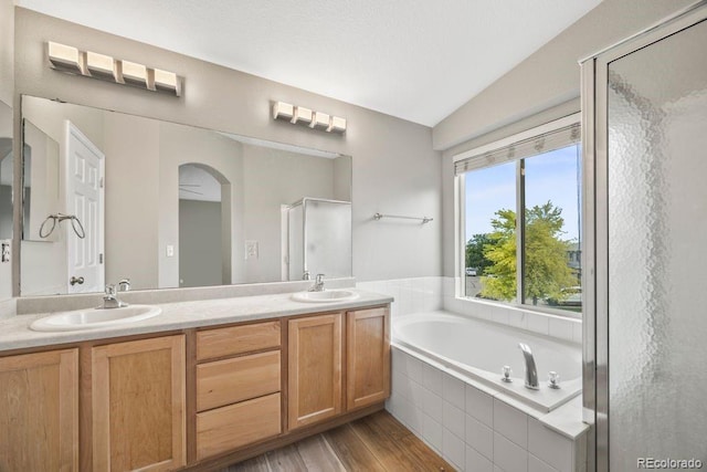 5796 E 129th Pl, Thornton, CO 80602 - bathroom featuring a garden tub, a stall shower, lofted ceiling, double vanity, and wood finished floors