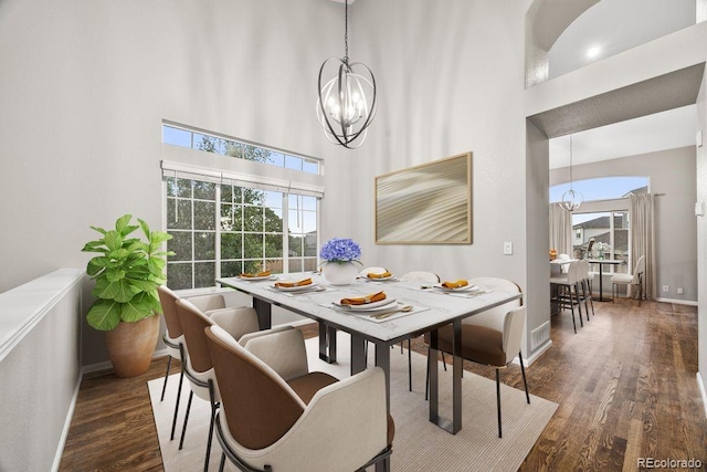 5796 E 129th Pl, Thornton, CO 80602 - dining area featuring a chandelier, wood finished floors, and a towering ceiling
