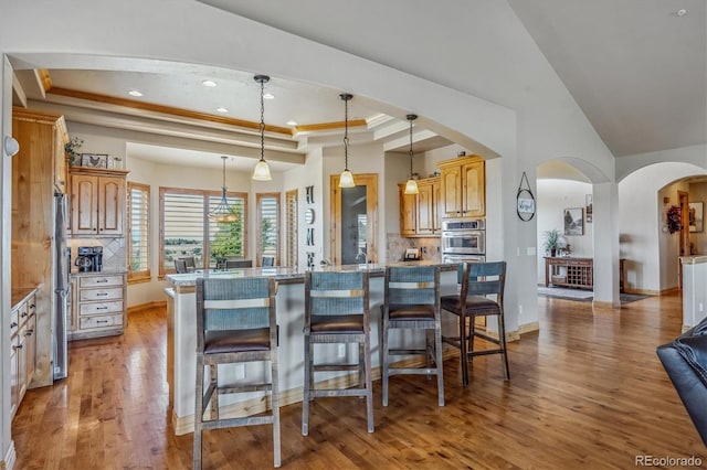 11624 Dunrich Rd, Parker, CO 80138 - kitchen featuring backsplash, a kitchen bar, freestanding refrigerator, light wood finished floors, and a raised ceiling