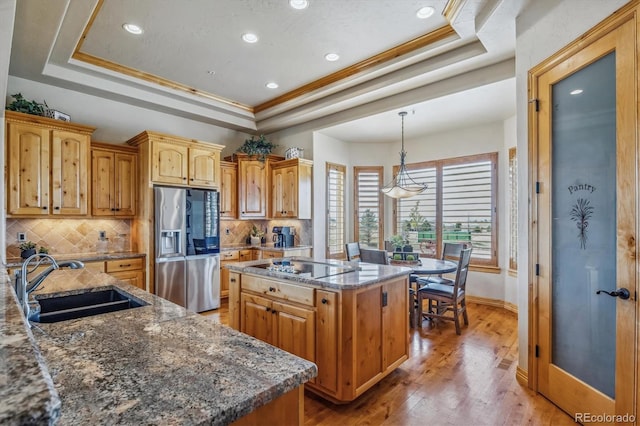 11624 Dunrich Rd, Parker, CO 80138 - kitchen with stainless steel refrigerator with ice dispenser, a tray ceiling, a kitchen island, black electric stovetop, and backsplash