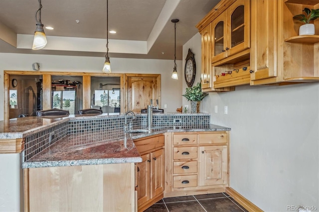 11624 Dunrich Rd, Parker, CO 80138 - kitchen with open shelves, a tray ceiling, a peninsula, stone countertops, and glass insert cabinets