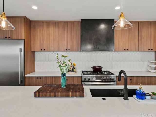 1612 Wolff St, Denver, CO 80204 - kitchen with range hood, high quality appliances, brown cabinetry, hanging light fixtures, and recessed lighting