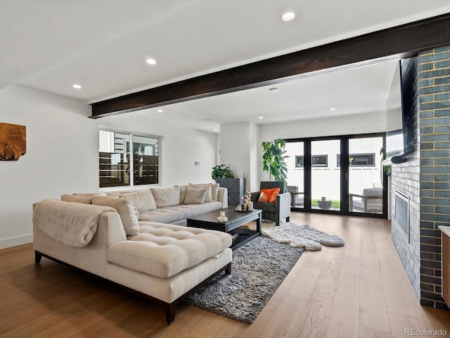 1612 Wolff St, Denver, CO 80204 - living area featuring wood finished floors, beamed ceiling, healthy amount of natural light, a brick fireplace, and recessed lighting