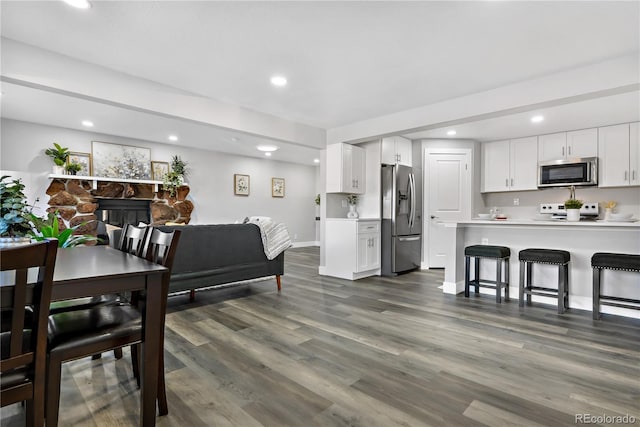 dining room featuring dark wood-type flooring and a fireplace