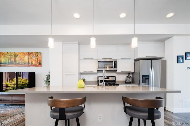 5630 W 11th Pl, Lakewood, CO 80214 - kitchen with stainless steel appliances, recessed lighting, white cabinetry, modern cabinets, and a kitchen breakfast bar