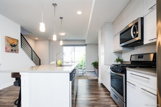 5630 W 11th Pl, Lakewood, CO 80214 - kitchen with stainless steel appliances, a sink, modern cabinets, a kitchen breakfast bar, and baseboards