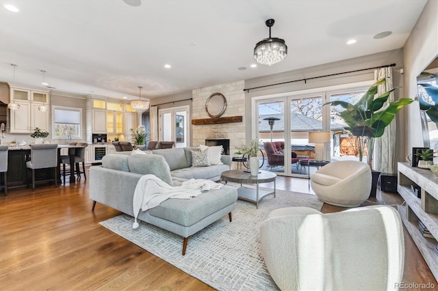 2600 S Adams St, Denver, CO 80210 - living room featuring a fireplace, light wood-style flooring, a chandelier, and recessed lighting