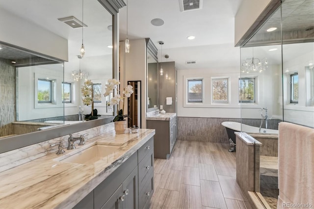 2600 S Adams St, Denver, CO 80210 - full bathroom featuring a chandelier, two vanities, and a freestanding tub