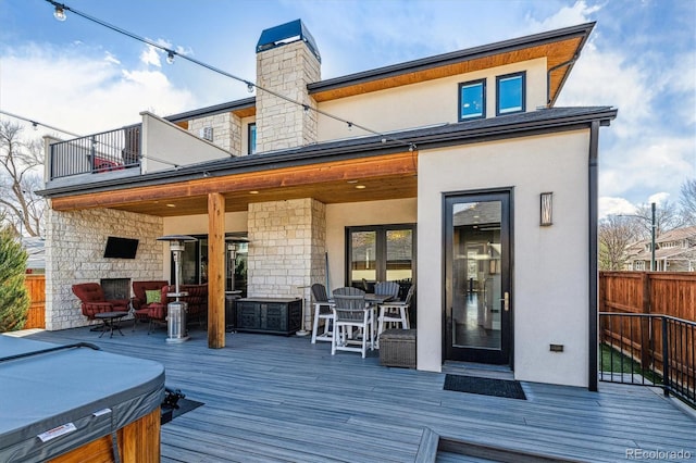 2600 S Adams St, Denver, CO 80210 - back of property with a deck, outdoor dining area, stone siding, a balcony, and stucco siding