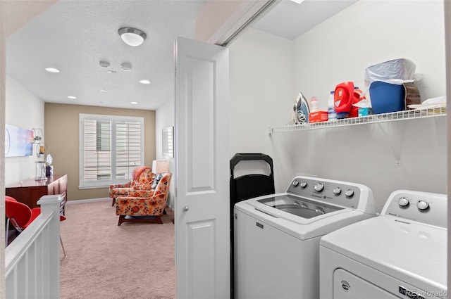 laundry area with independent washer and dryer, a textured ceiling, and light colored carpet