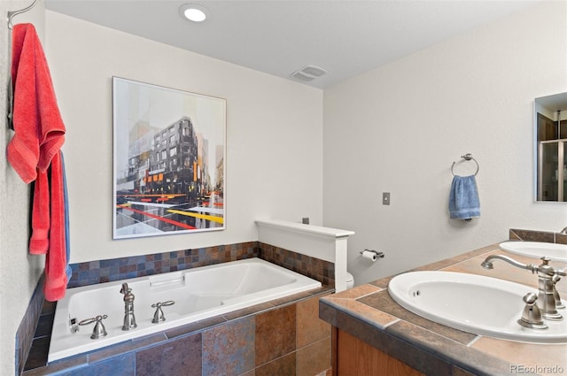 bathroom with tiled bath and vanity