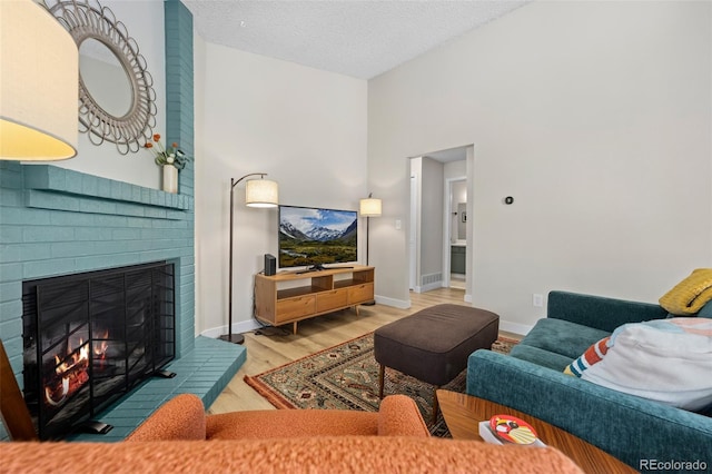 8378 S Upham Way Unit B305, Littleton, CO 80128 - living area featuring a brick fireplace, wood finished floors, and a textured ceiling