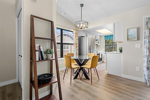 8378 S Upham Way Unit B305, Littleton, CO 80128 - dining space with a chandelier, plenty of natural light, a textured ceiling, light wood finished floors, and lofted ceiling