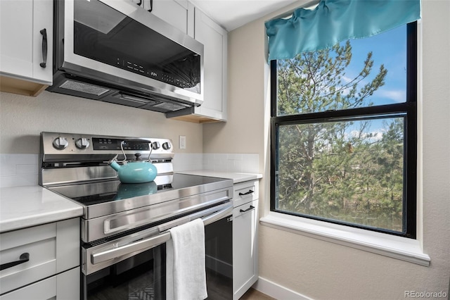 8378 S Upham Way Unit B305, Littleton, CO 80128 - kitchen featuring stainless steel appliances, plenty of natural light, light countertops, and white cabinetry