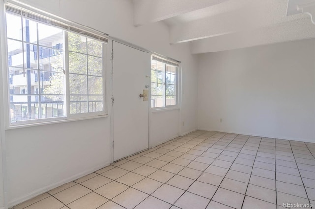 entryway featuring beam ceiling and light tile patterned flooring