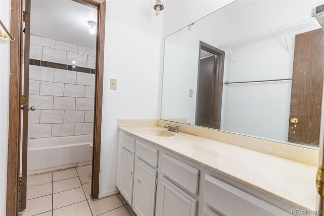 bathroom featuring tile patterned flooring, vanity, and tiled shower / bath combo