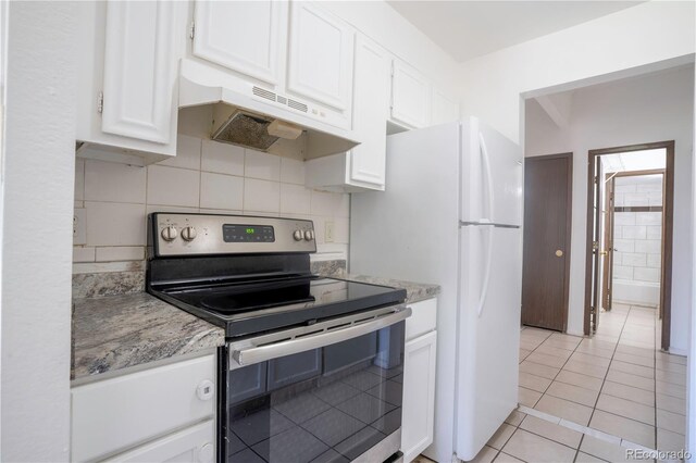 kitchen with white cabinets, electric range, light stone countertops, and light tile patterned flooring