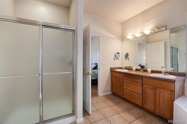 bathroom with a shower with shower door, vanity, and tile patterned floors