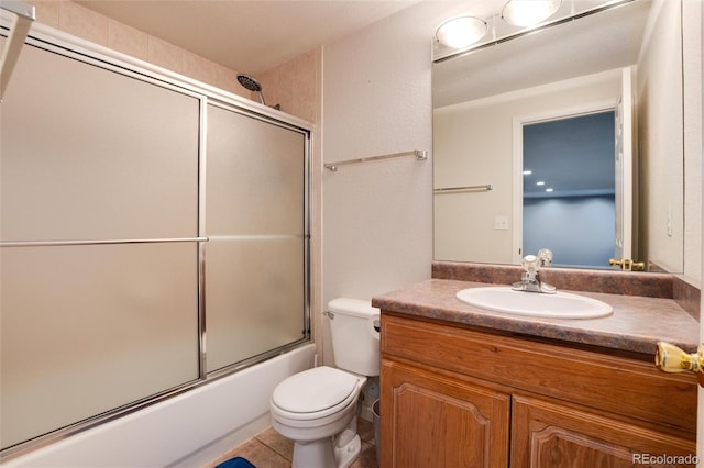 full bathroom with tile patterned floors, combined bath / shower with glass door, vanity, and toilet