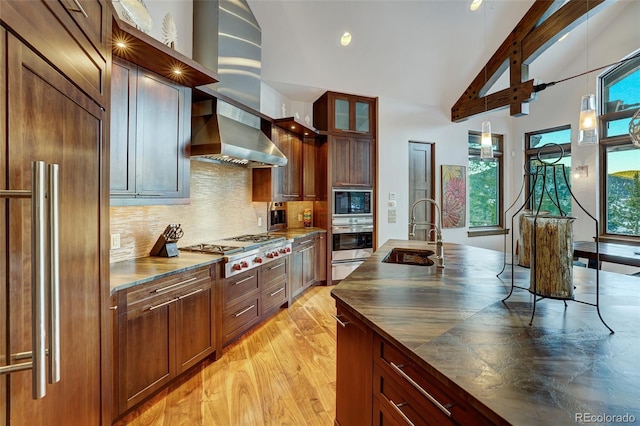 kitchen with sink, paneled built in fridge, a wealth of natural light, stainless steel gas stovetop, and backsplash