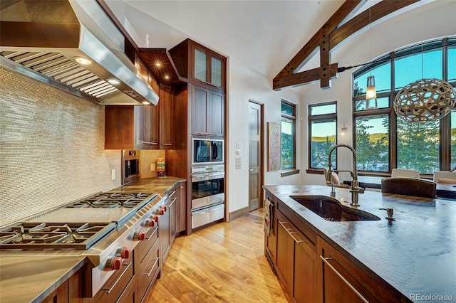 kitchen with sink, extractor fan, light hardwood / wood-style flooring, appliances with stainless steel finishes, and backsplash