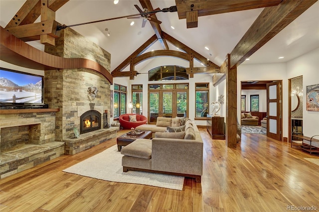 living room with high vaulted ceiling, a fireplace, light hardwood / wood-style floors, french doors, and beamed ceiling