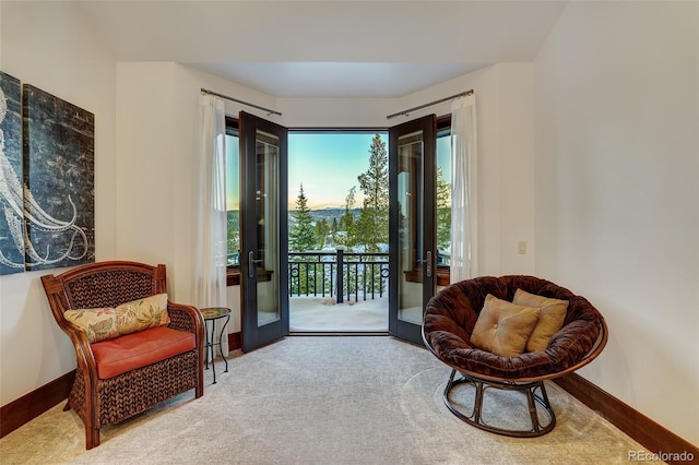 sitting room with french doors and light colored carpet