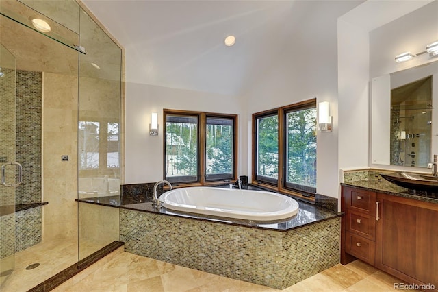 bathroom featuring independent shower and bath, vanity, and vaulted ceiling