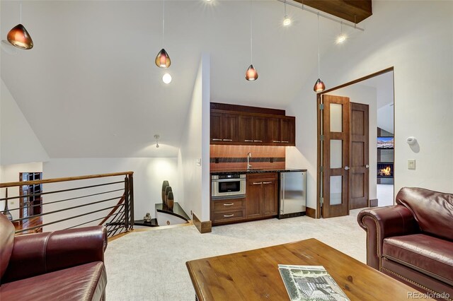 carpeted living room with high vaulted ceiling and sink