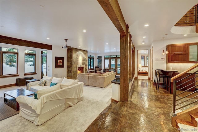 living room with beamed ceiling, a healthy amount of sunlight, and a fireplace