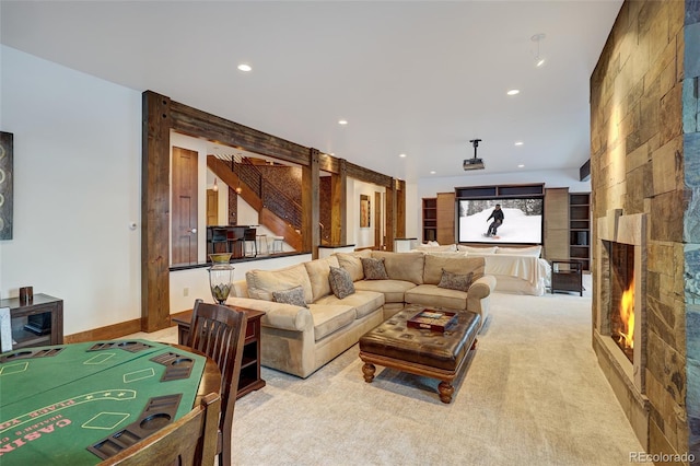 carpeted living room featuring a stone fireplace