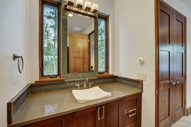 bathroom with tasteful backsplash, vanity, and a wealth of natural light