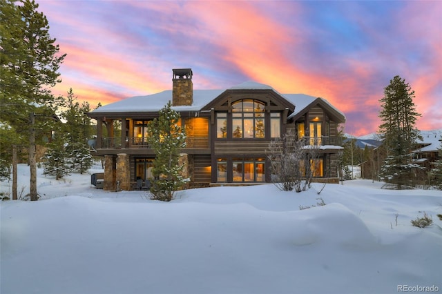 view of snow covered back of property