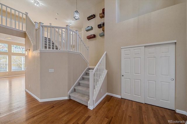 6317 Ruby Hill Dr, Erie, CO 80516 - stairway featuring baseboards, wood finished floors, and a towering ceiling