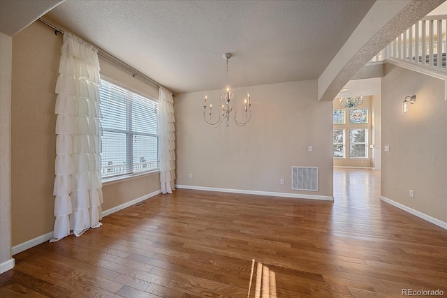 6317 Ruby Hill Dr, Erie, CO 80516 - unfurnished dining area featuring a chandelier, visible vents, a wealth of natural light, and hardwood / wood-style flooring