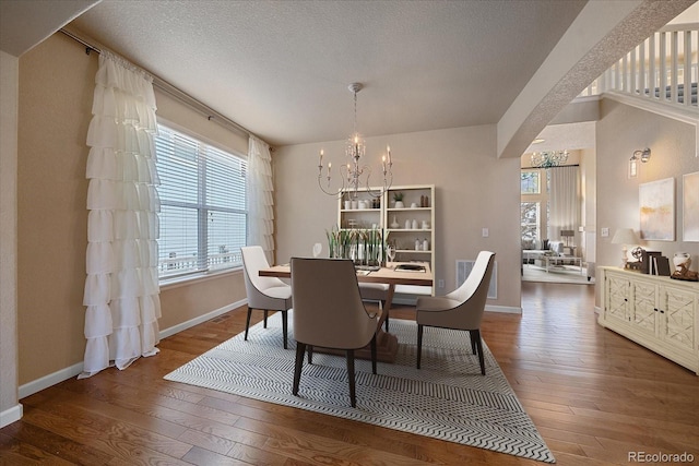 6317 Ruby Hill Dr, Erie, CO 80516 - dining room featuring wood-type flooring, baseboards, a chandelier, and a healthy amount of sunlight