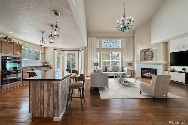 6317 Ruby Hill Dr, Erie, CO 80516 - kitchen with dobule oven black, a chandelier, dark countertops, dark wood finished floors, and open floor plan