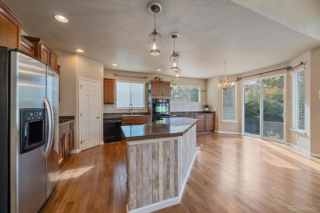 6317 Ruby Hill Dr, Erie, CO 80516 - kitchen featuring brown cabinets, a textured ceiling, a sink, and black appliances