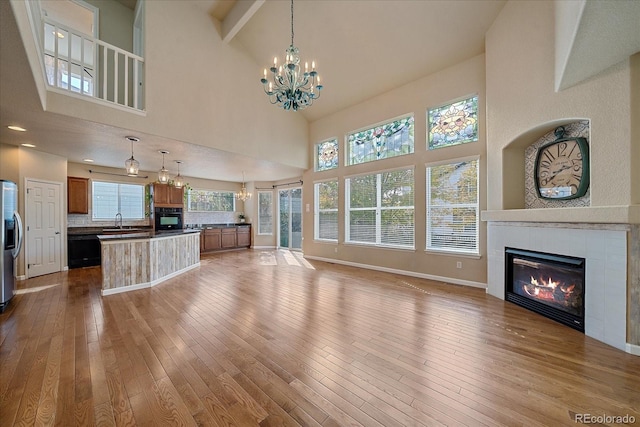 6317 Ruby Hill Dr, Erie, CO 80516 - unfurnished living room featuring a high ceiling, an inviting chandelier, a glass covered fireplace, and a sink