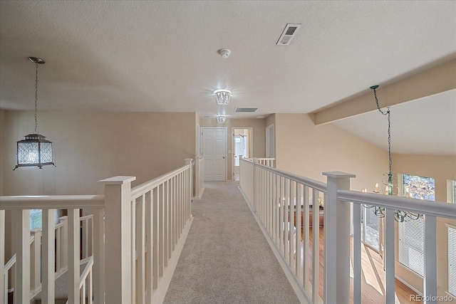 6317 Ruby Hill Dr, Erie, CO 80516 - hall with visible vents, light carpet, a chandelier, and a wealth of natural light