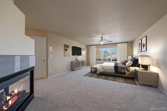 6317 Ruby Hill Dr, Erie, CO 80516 - bedroom with baseboards, carpet flooring, a textured ceiling, and a fireplace