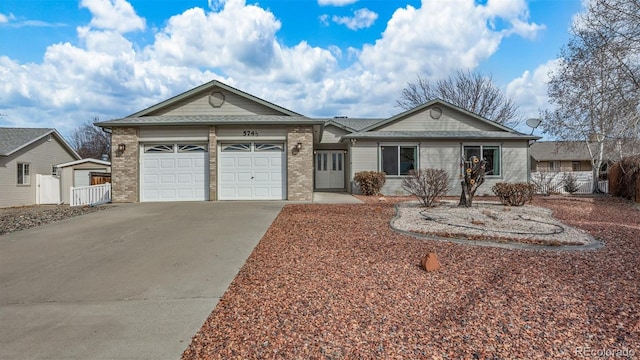 ranch-style home with a garage, concrete driveway, brick siding, and fence