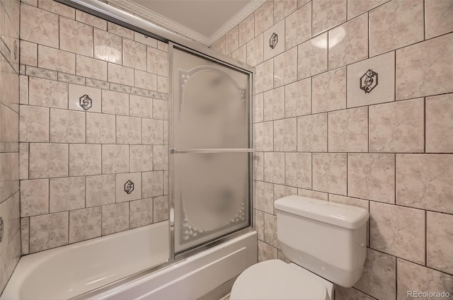 full bathroom with tile walls, bath / shower combo with glass door, toilet, and ornamental molding