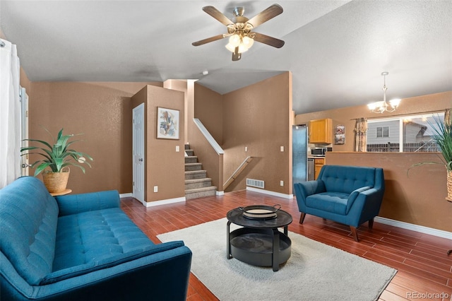 living room with vaulted ceiling, ceiling fan with notable chandelier, and wood-type flooring