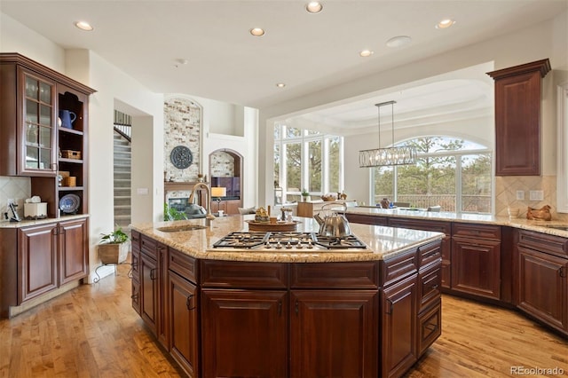 kitchen featuring a center island, sink, hanging light fixtures, and light wood-type flooring