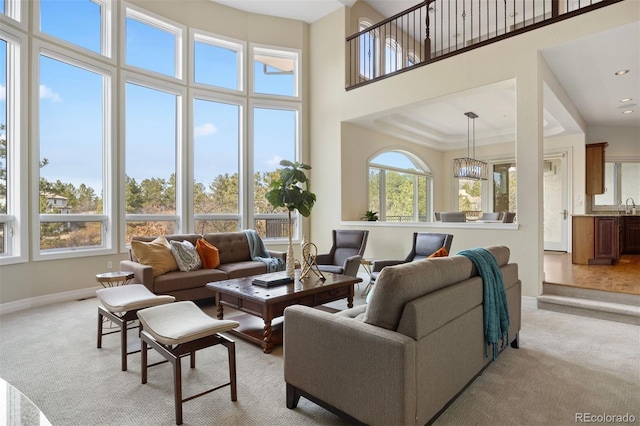 carpeted living room with sink and a towering ceiling