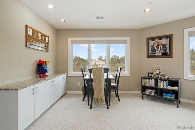 dining space featuring light carpet