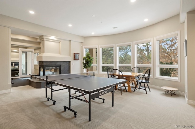 recreation room featuring a fireplace and light colored carpet