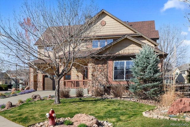 4236 Frederick Cir, Longmont, CO 80503 - view of front of house with stone siding, concrete driveway, a front lawn, and a garage