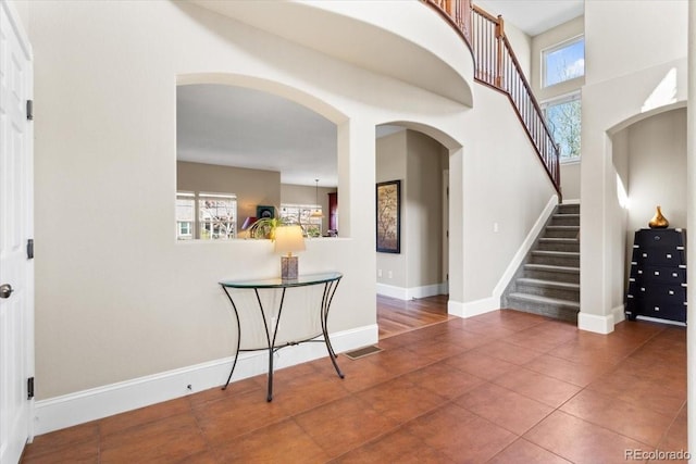 4236 Frederick Cir, Longmont, CO 80503 - entryway with arched walkways, stairs, tile patterned flooring, and baseboards